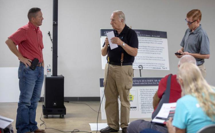 Matt Swearengin | Durant Democrat Don Grube, middle, talks to U.S. Rep. Josh Brecheen during a town hall meeting last week at the fairgrounds.