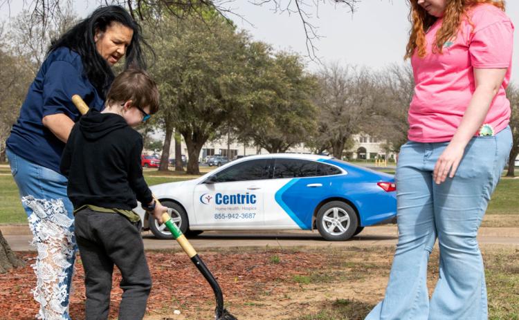 A time capsule was buried last Friday at Oxford Springs Durant assisted living center. Seven-year-old Zander Babb helped with the burial and also shown are his grandmother Lisa Gibson, left, who is a CNA and CMA at Oxford, and Kenley Hayes, life enrichment director of Oxford. Matt Swearengin | Durant Democrat