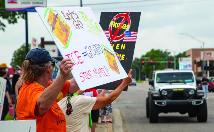 Demonstrators line the sidewalk on West Main Street at 12th Avenue during a protest Saturday afternoon.