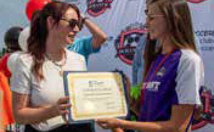 Durant Area Chamber of Commerce CEO Kara Byrd presents Durant Soccer Club board member Kayla Catiller with a certificate welcoming the club to the chamber of commerce. Matt Swearengin | Durant Democrat