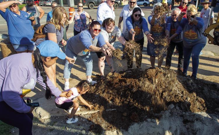 Dirt is thrown during the burial of the time capsule June 14 in front of the Big Peanut at Durant City Hall. It will be opened in 50 years. Matt Swearengin | Durant Democrat